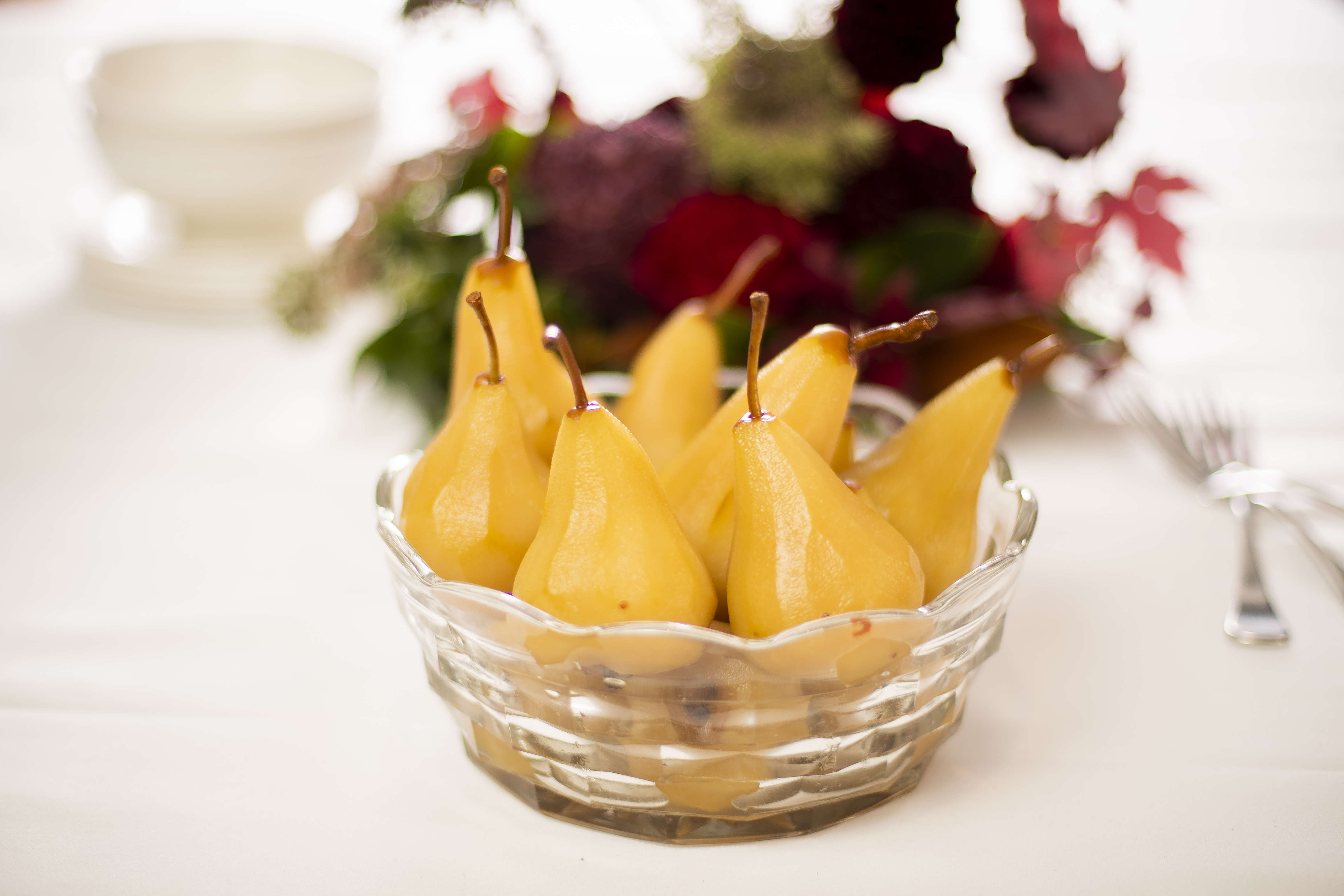 Seven pears that have been poached in saffron syrup in a cut glass bowl. Photo: Richard Jupe.